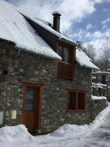 a stone house with snow on top of it at Chez Pépé in Génos