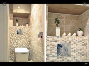 a bathroom with a toilet and a tiled wall at Cosy Marais Paris in Paris