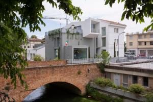 un puente sobre un río con un edificio en Ai Bastioni Boutique Hotel, en Treviso