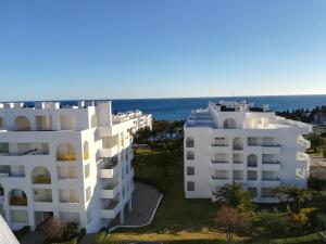 an aerial view of two white buildings and the ocean at Apartamento Varandas do Sol Nascente in Porches