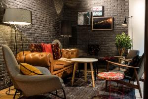 a living room with a couch and a brick wall at Laz' Hotel Spa Urbain Paris in Paris