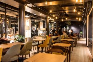 a restaurant with tables and chairs and people in the background at Laz' Hotel Spa Urbain Paris in Paris