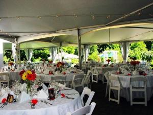 a banquet hall with white tables and chairs with flowers at Lilac Inn in Brandon