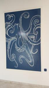 a painting of an octopus on a blue background at Sloth in Rab