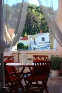 a table and chairs on a balcony with a view at Sloth in Rab