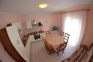 a kitchen and dining room with a table and chairs at Sloth in Rab