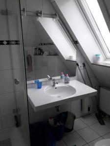 a bathroom with a sink and a mirror at Messe Zimmer Düsseldorf Airport in Düsseldorf