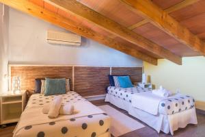 zwei Betten in einem Zimmer mit Holzdecken in der Unterkunft 113 Finca Can Roig ETV955 by Mallorca Charme in Alcúdia