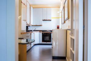 a kitchen with white cabinets and a white refrigerator at Amarcord casa vacanze in Alberobello +22 photos