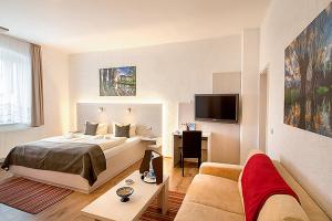 a bedroom with a bed and a desk and a couch at Kartoffelgasthaus & Pension Knidle in Lübbenau