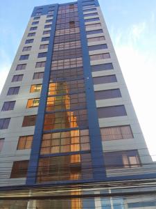 un edificio alto con su reflejo en las ventanas en HB Apartament Sopocachi, en La Paz