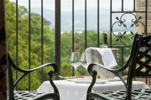 a table with two chairs and a table with wine glasses at Armathwaite Hall Hotel & Spa in Bassenthwaite