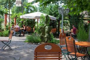 a patio with a fountain and people sitting at tables at Kartoffelgasthaus & Pension Knidle in Lübbenau