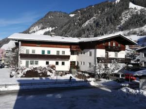 un grand bâtiment blanc avec une montagne en arrière-plan dans l'établissement Gästehaus Anna, à Grossarl