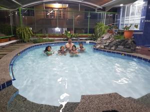a man and his family in a swimming pool at Fuentes del Volcán in Baños