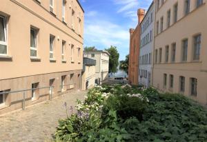 un callejón entre dos edificios con flores en Schwerin Apartment am Pfaffenteich en Schwerin