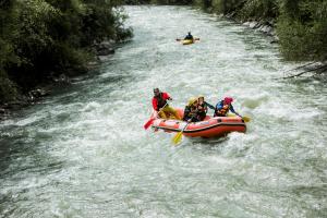 Alpen Ferienwohnung II في Lappago: مجموعة من الناس على طوف في نهر