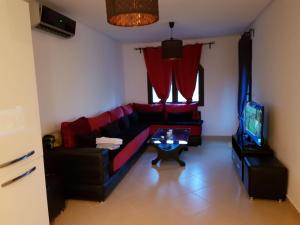 a living room with a red couch and a tv at Appartement B-23 Cabo Négro in Cabo Negro