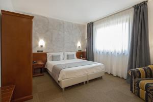 a hotel room with a bed and a window at Hotel Medea - Adults Only in Alba