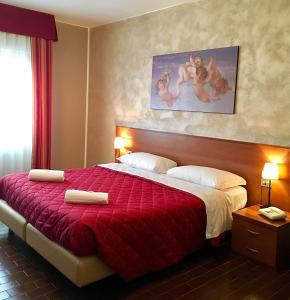 Habitación de hotel con cama con colcha roja en Hotel Forum, en Rozzano