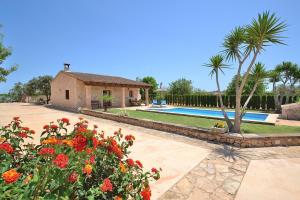 a villa with a swimming pool and a garden with flowers at Finca Estret 184 by Mallorca Charme in Santa Margalida
