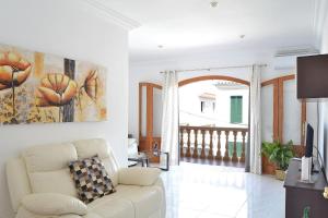 Villa Desaigüa 167 by Mallorca Charme في يوبي: غرفة معيشة مع أريكة ولوحة على الحائط