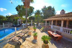 un patio con mesas y sillas junto a una casa en Villa Can Bisbe 187 by Mallorca Charme, en Muro