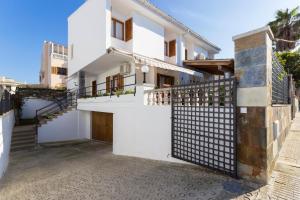 a house with white walls and a gate at Casa Confitets 218 by Mallorca Charme in Can Picafort