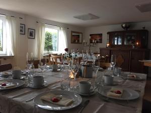 a dining room with a table with plates and glasses at Gästehaus Zur Linde in Otterndorf