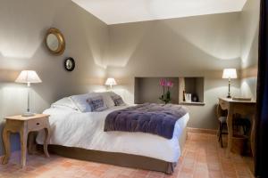 a bedroom with a bed and two tables and a mirror at Château de Pierreclos in Pierreclos