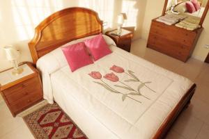 um quarto com uma cama com almofadas cor-de-rosa em Hospedaje Pension Tabares em Zas