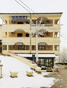 un hotel con nieve frente a un edificio en Hotel La Falconara en Castrovillari