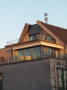 een huis met een balkon bovenop een gebouw bij Vakantie Appartement Ella in De Haan