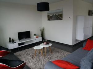 een woonkamer met een bank en een tafel bij Vakantie Appartement Ella in De Haan