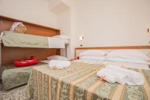 una habitación de hotel con 2 camas y toallas en una mesa en Hotel Oregon, en Rímini