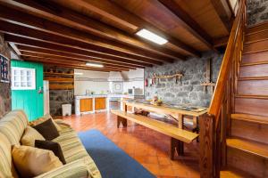 uma cozinha e sala de estar com uma mesa de madeira em Adega Lopes em Santo Amaro