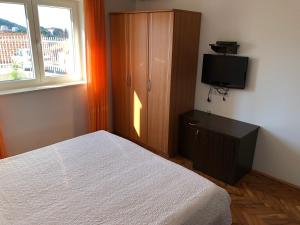 a bedroom with a bed and a cabinet and a television at Guesthouse Victoria in Dubrovnik