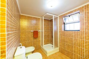 La salle de bains est pourvue de toilettes, d'une douche et d'une fenêtre. dans l'établissement Adega Lopes, à Santo Amaro