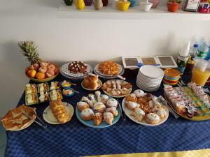 uma mesa com muitos tipos diferentes de pastelarias e sobremesas em Athena Bed & Breakfast em San Vito lo Capo