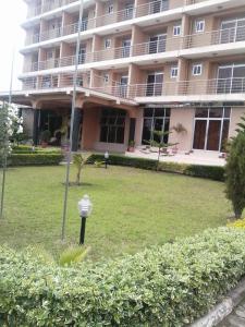 ein großes Gebäude mit Rasen davor in der Unterkunft Western Meridian Hotel Ltd Bushenyi in Bushenyi