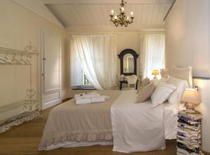 a bedroom with a large white bed with a chandelier at B&B Di Camilla in Pisa +64 photos