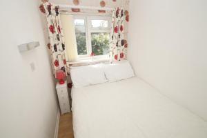 um pequeno quarto com uma cama e uma janela em 2 Bed Apartment w/private access to 7 miles of sandy beach - Sleeps 4 em Brean