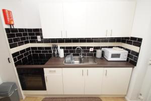 a small kitchen with a sink and a microwave at 2 Bed Apartment w/private access to 7 miles of sandy beach - Sleeps 4 in Brean