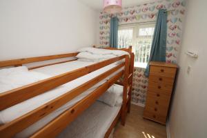 een slaapkamer met 2 stapelbedden en een raam bij 2 Bed Apartment w/private access to 7 miles of sandy beach - Sleeps 4 in Brean