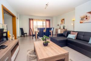 een woonkamer met een blauwe bank en een tafel bij Pegada By Algartur in Tavira