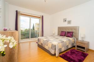 een slaapkamer met een bed en een groot raam bij Pegada By Algartur in Tavira