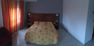 A bed or beds in a room at Hotel Perales