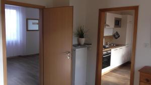 eine Küche mit einer Tür, die sich zu einer Küche mit einer Spüle öffnet in der Unterkunft Balles in Ellenz-Poltersdorf