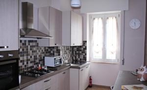 a kitchen with white cabinets and a stove and a window at Casa di Giulia in Caserta