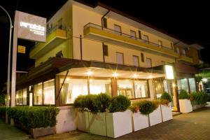 um edifício com plantas à sua frente à noite em Albergo Ristorante Protti em Cattolica